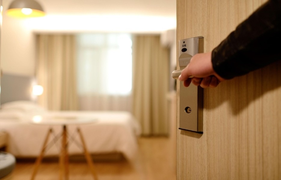 person öppnar dörr till hotellrum
